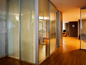 Modern office interior with glass partitions, creating private workspaces.