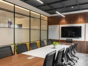 Modern office meeting room with frosted glass room separator and wooden wall panelling